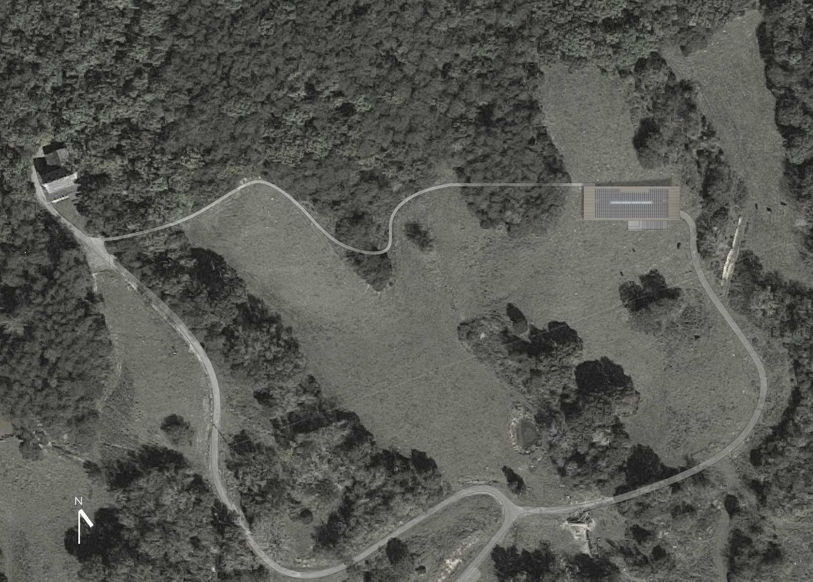 Aerial photograph of the wooded property, a winding drive leading up to the house on its knoll