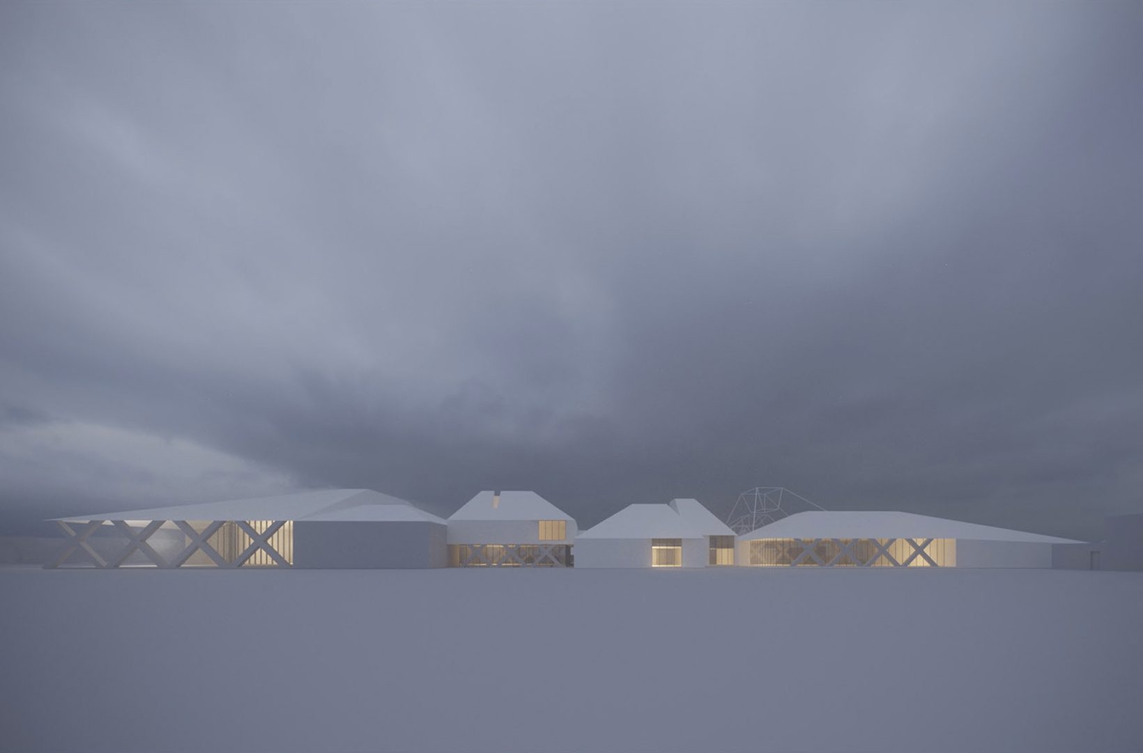The school at dusk seen from the park, small pitched roofs lit from within