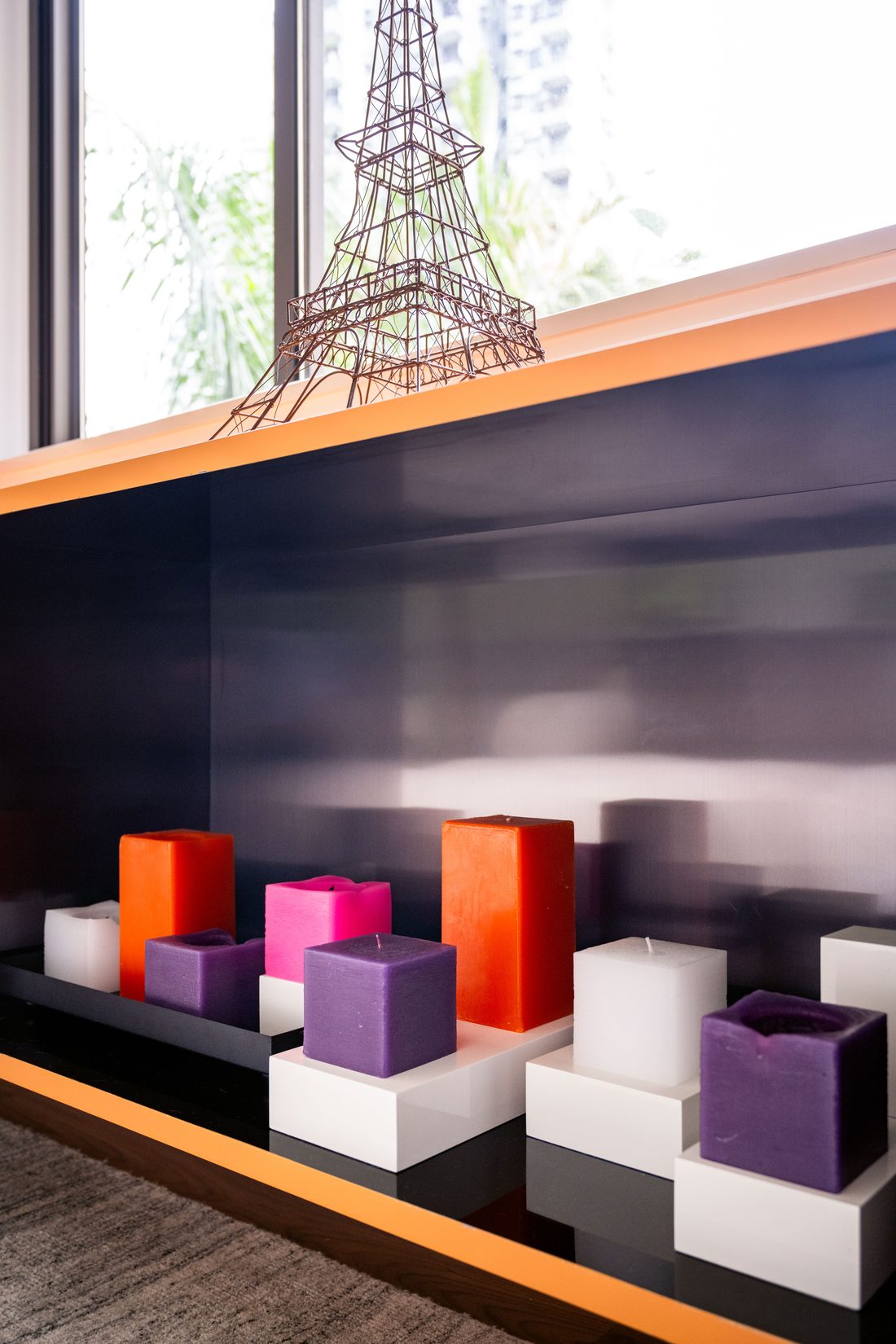An open compartment in the apricot cabinet, lined in dark blue, holding coloured blocks