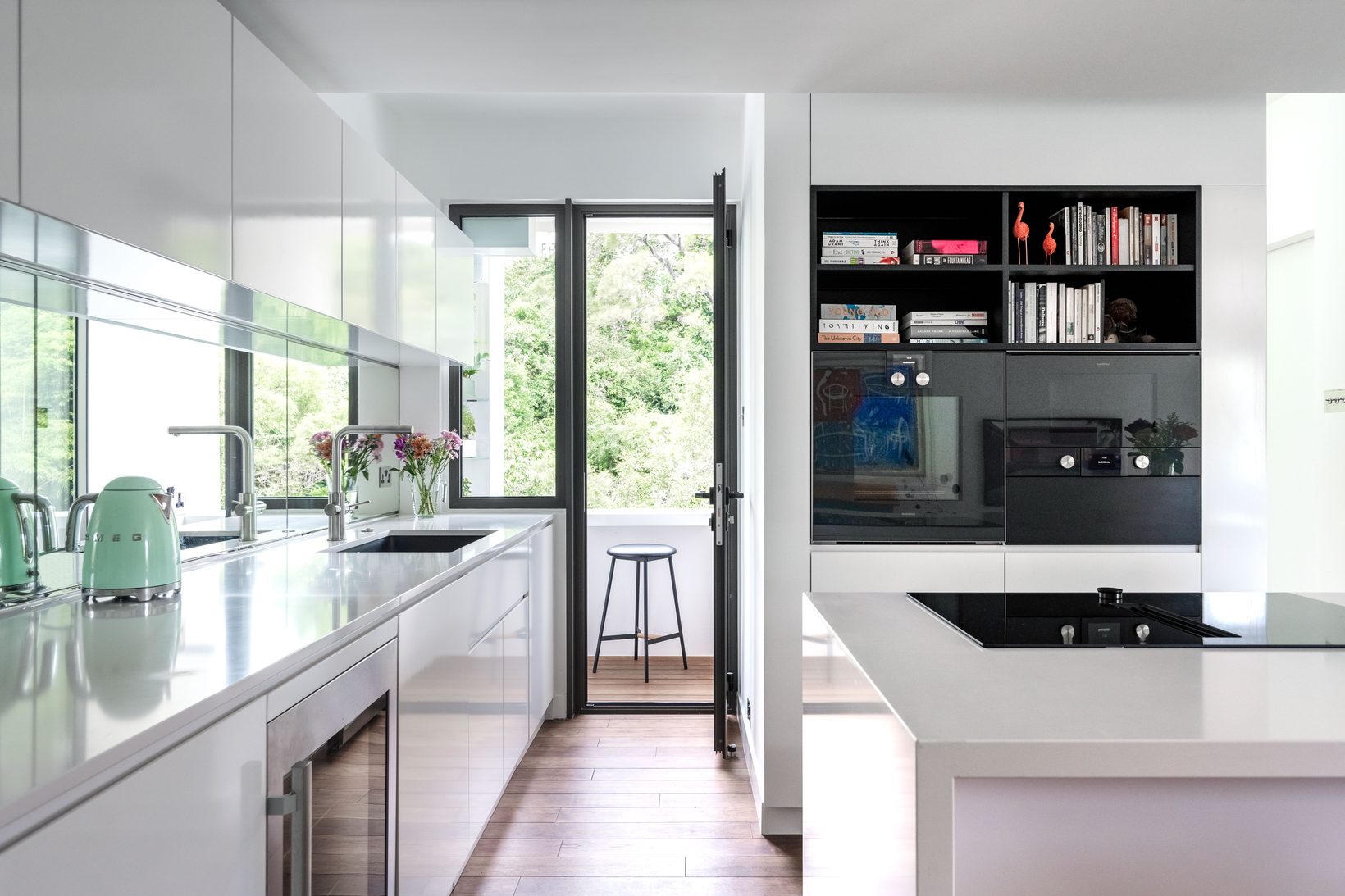 The kitchen counter running toward a glazed door, with the hob set into the island
