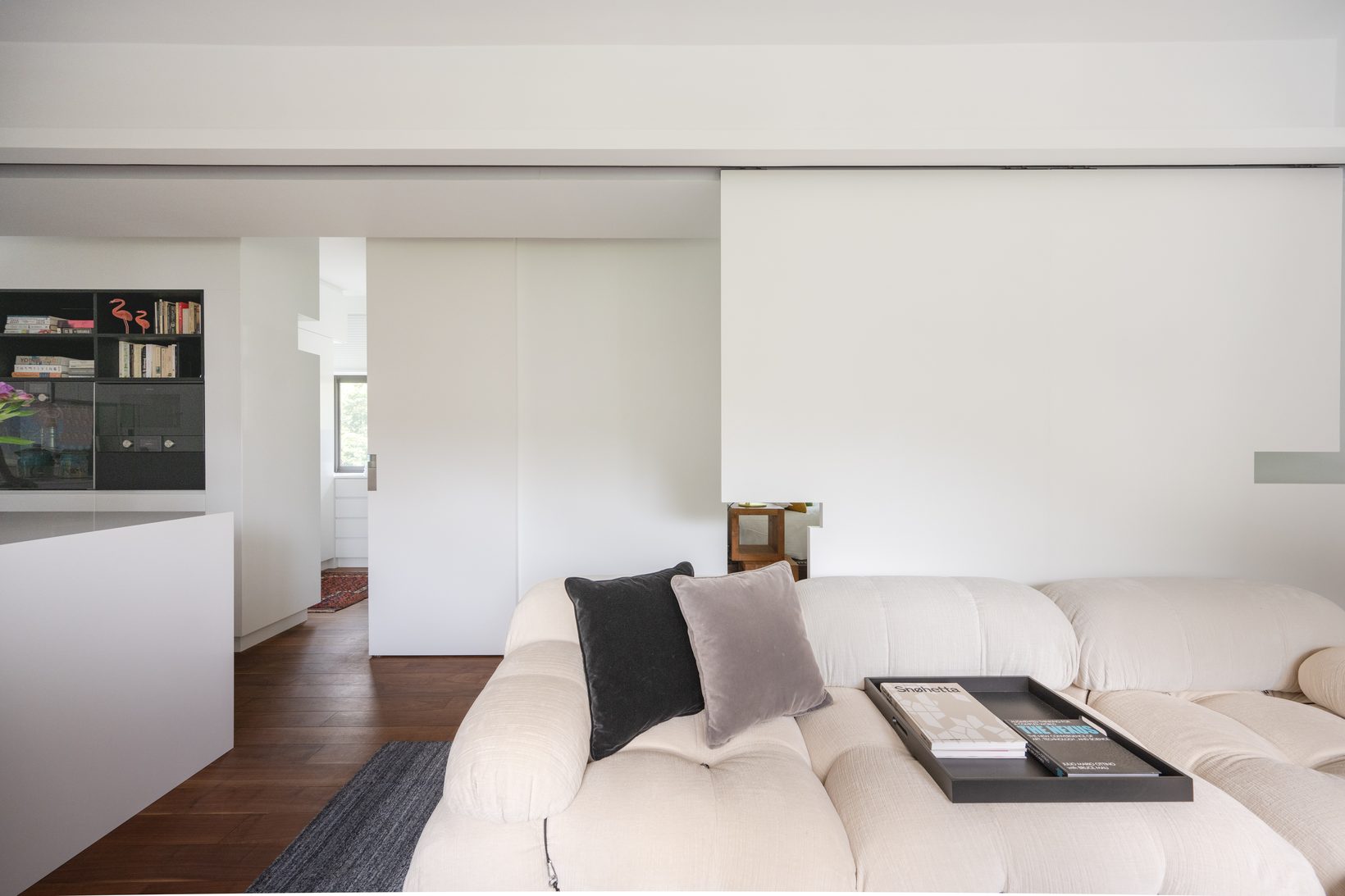 The sliding panel drawn across, closing the bedroom behind the sofa
