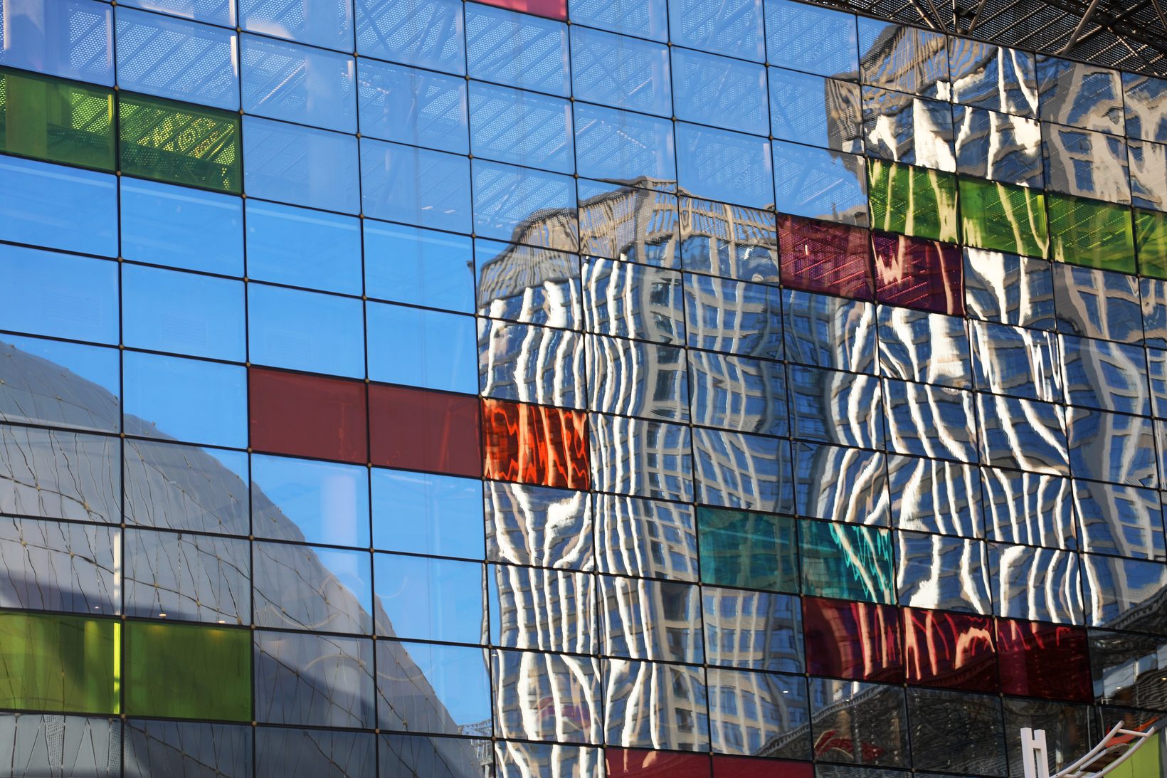 The commercial centre’s glass façade with red, green and yellow panels reflecting neighbouring towers