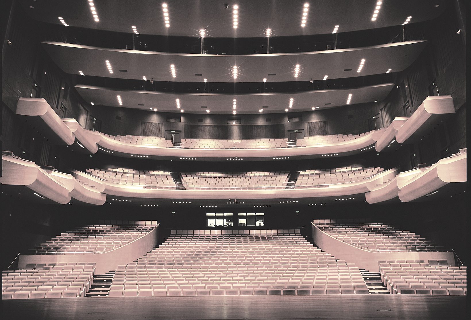 The hall seen from the stage: stalls and two curved balcony tiers