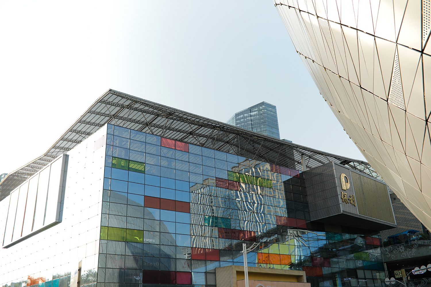The commercial centre’s coloured glass façade beside the curved edge of the theatre