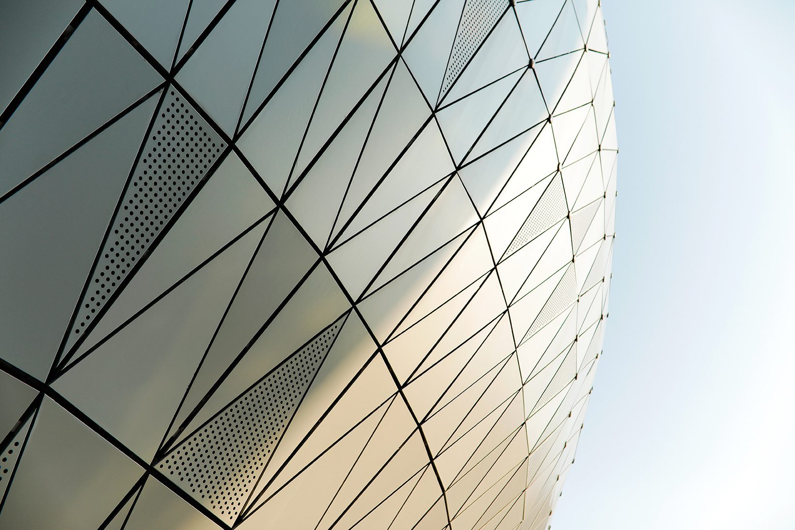 Close view of triangular metal and perforated panels following the curve of the skin