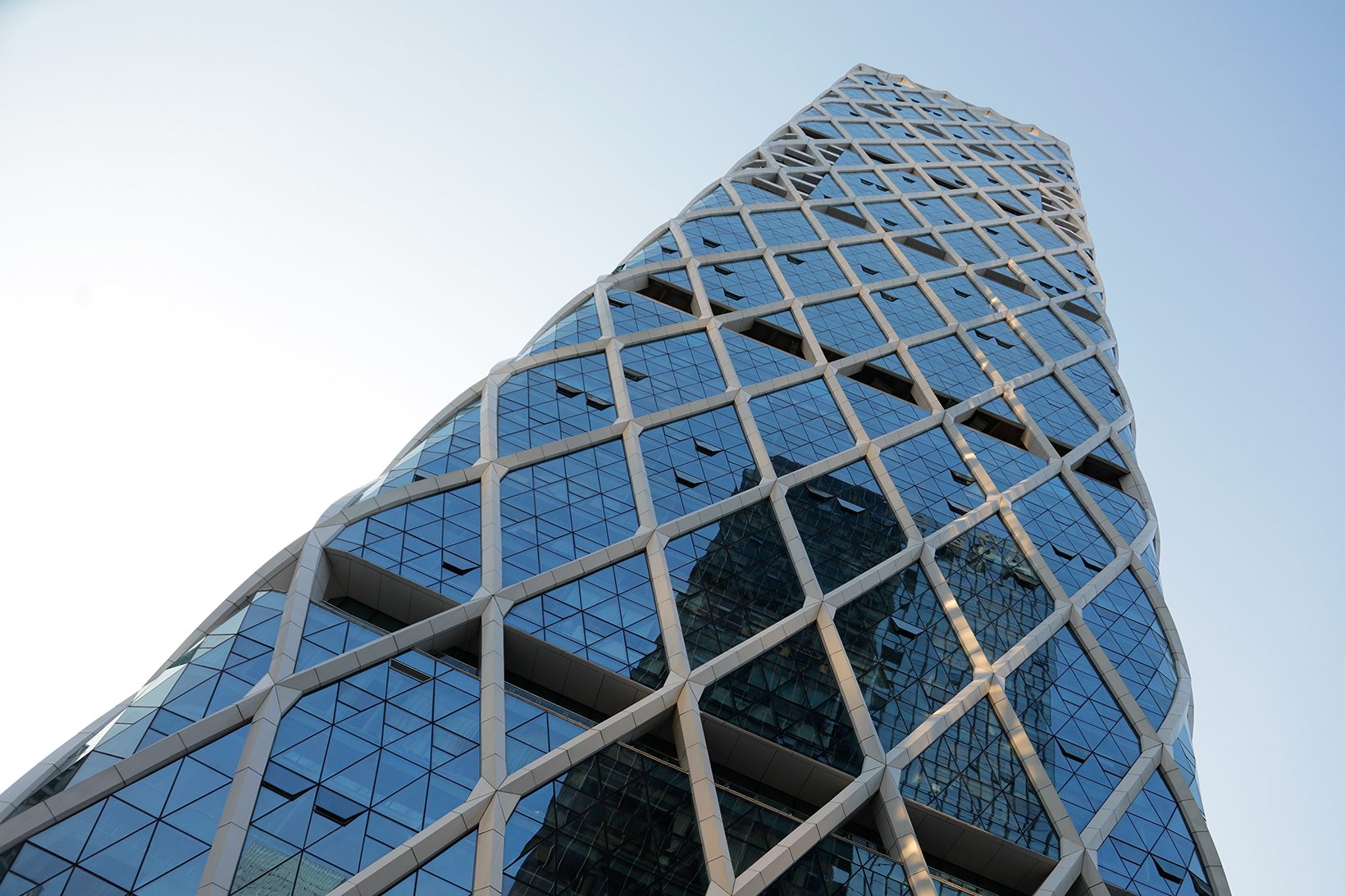 The tower’s edge rising against the sky, the diagrid tapering toward the crown