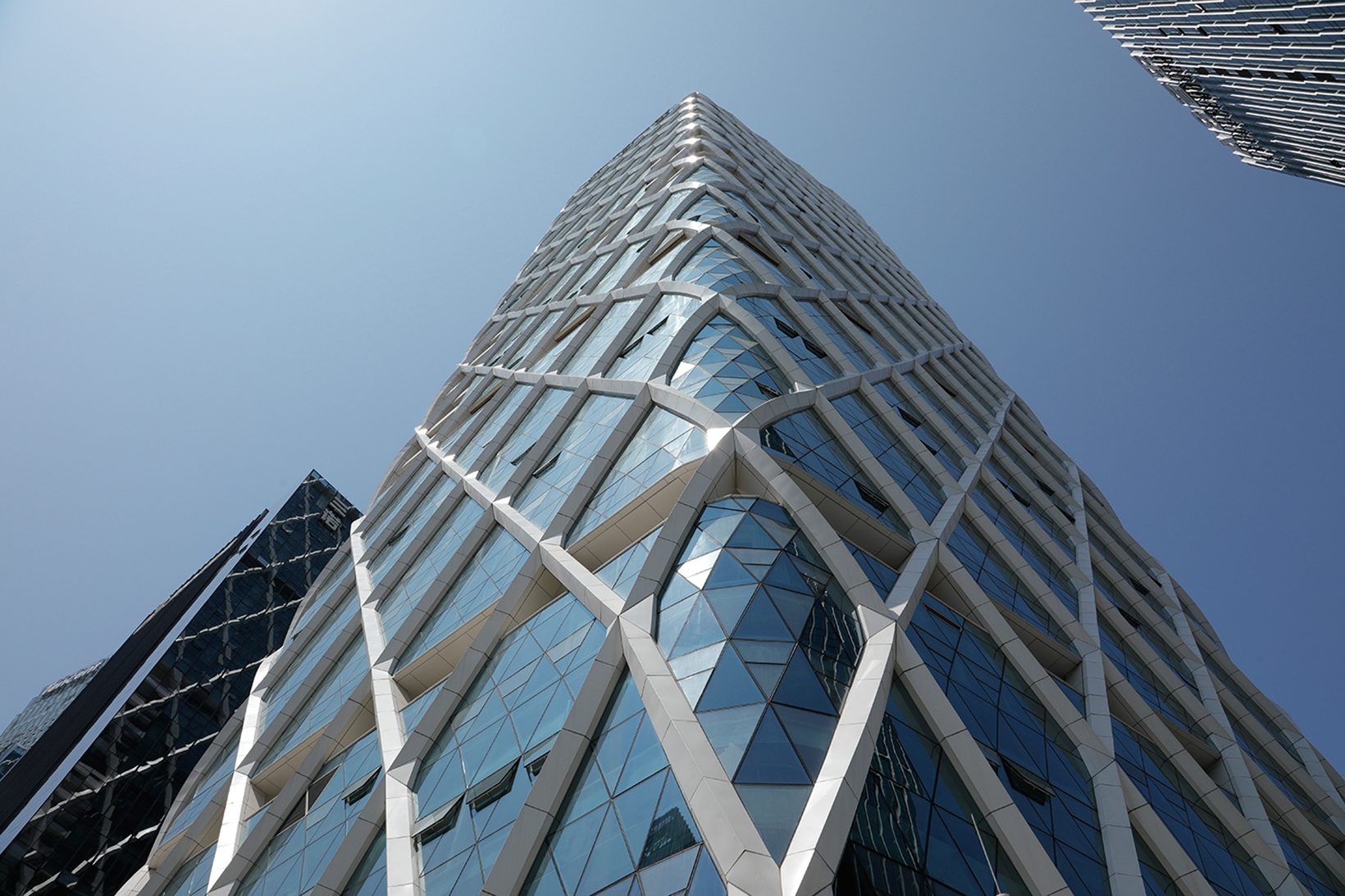 Low-angle view of the tower’s diagrid against blue sky